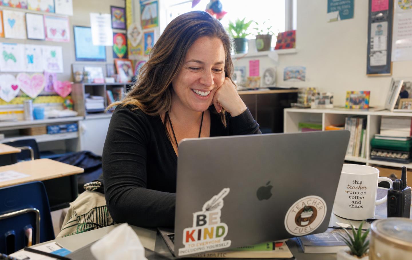 Teacher browsing live virtual field trip destinations on a laptop in a classroom